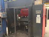 a large machine is sitting in a warehouse with its doors open