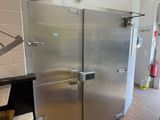 a stainless steel refrigerator in a kitchen with a brick floor