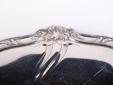 a silver plate with a bird on it on a table