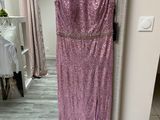a dress hanging on a hanger in front of a mirror