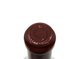 a close up of a bottle of wine on a white surface
