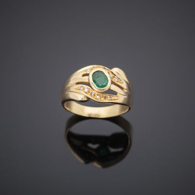 a gold ring with an emerald stone and diamonds