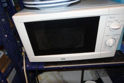 a microwave that is sitting on a shelf in a room
