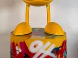 un jouet jaune posé sur une boîte recouverte de graffitis