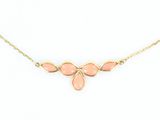 un collier en or orné de pierres roses sur fond blanc