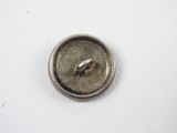 silver metal button with a ring on it on a white surface