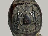 un vase noir orné d'un motif sur fond gris