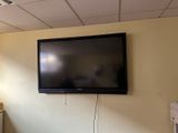 un téléviseur à écran plat fixé au mur d'une pièce