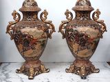 une paire de vases anciens posés sur une table en marbre rehaussée de touches dorées