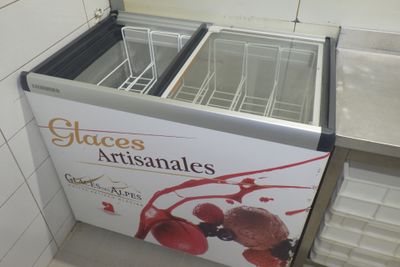une pancarte indiquant « verres artisanaux » devant un congélateur