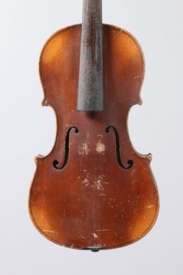 an old violin sitting on top of a white surface