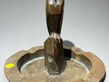 an image of a bronze owl statue sitting on top of a metal plate