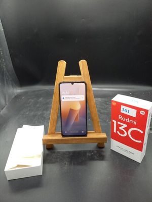 un téléphone portable posé sur un support à côté d'une boîte