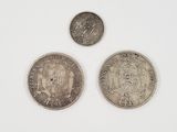three different types of silver coins on a white surface