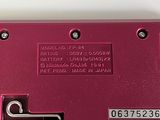a close up of a red electronic device on a white surface