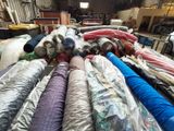 many rolls of fabric on the floor in a warehouse