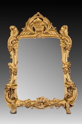 un miroir richement sculpté, orné d'un motif représentant des oiseaux et des fleurs
