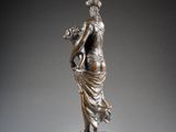 an antique bronze statue of a woman holding a basket of flowers