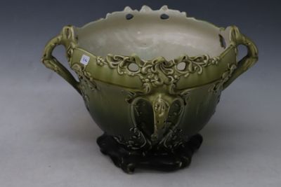 a green bowl with a handle on a stand
