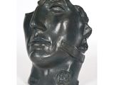 une image représentant une sculpture en bronze représentant la tête d'un homme aux yeux fermés