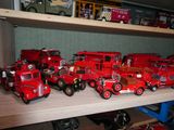 de nombreux camions de pompiers miniatures posés sur une étagère dans une pièce