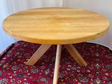 wooden table with four legs on a red carpeted area