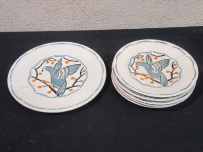 two plates with birds on them sitting on a table