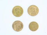 quatre types différents de pièces d'or sur une surface blanche