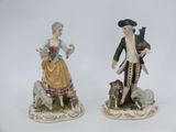 deux figurines d'un homme et d'une femme avec un chien