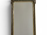 un miroir ancien dans un cadre doré, accroché à un mur blanc sur fond blanc