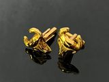 two pairs of gold plated cufflinks on a black surface
