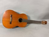 une petite guitare en bois posée sur un drap blanc