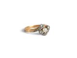a close up of a diamond and pearl ring on a white background