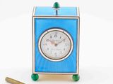 a small blue clock sitting next to a pair of scissors