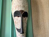 un masque accroché au mur d'une maison