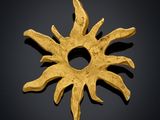 an image of a gold sun pendant on a black background