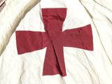 a red cross on a white sheet on a bed