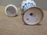 two blue and white vases sitting on a table