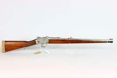a rifle with a wooden barrel and a wooden handle on a white surface
