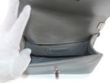 a person in white gloves holding a silver purse