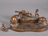 a bronze figurine of a man and a cannon on a base