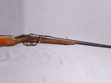 un vieux fusil avec un étui vert et une crosse en bois