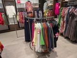 a rack of clothes in a clothing store with many shirts on it