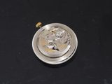 a small silver pocket watch on a black surface