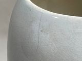 a close up of a white vase on a table