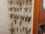 un mur de clés accrochées à un panneau perforé dans une pièce