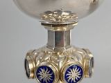 a silver goblet with blue and gold decorations on it