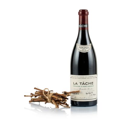bottle of red wine with a bunch of dried sticks next to it