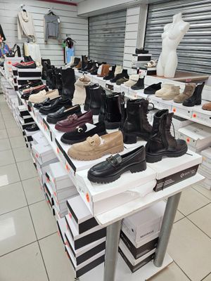 de nombreuses paires de chaussures posées sur une table dans un magasin de chaussures