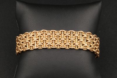 un bracelet en or posé sur un coussin noir